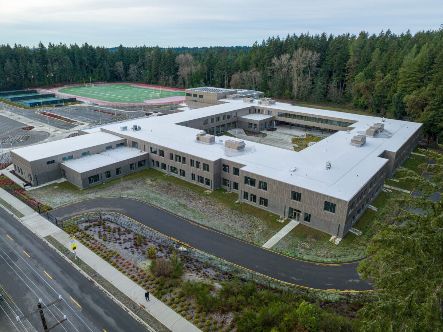 An aerial view of a school building in a forest.