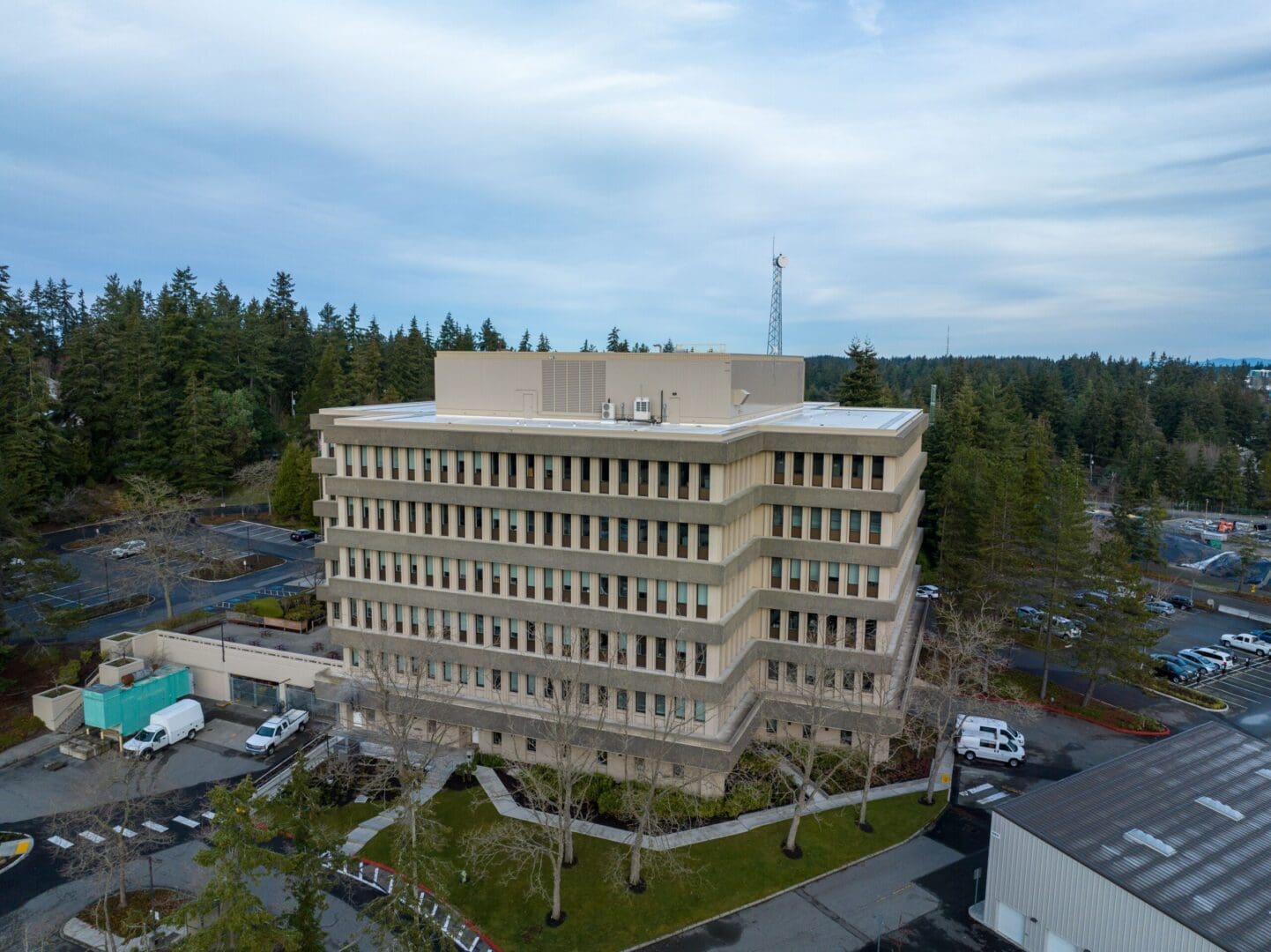 An aerial view of a large building in the middle of a forest.