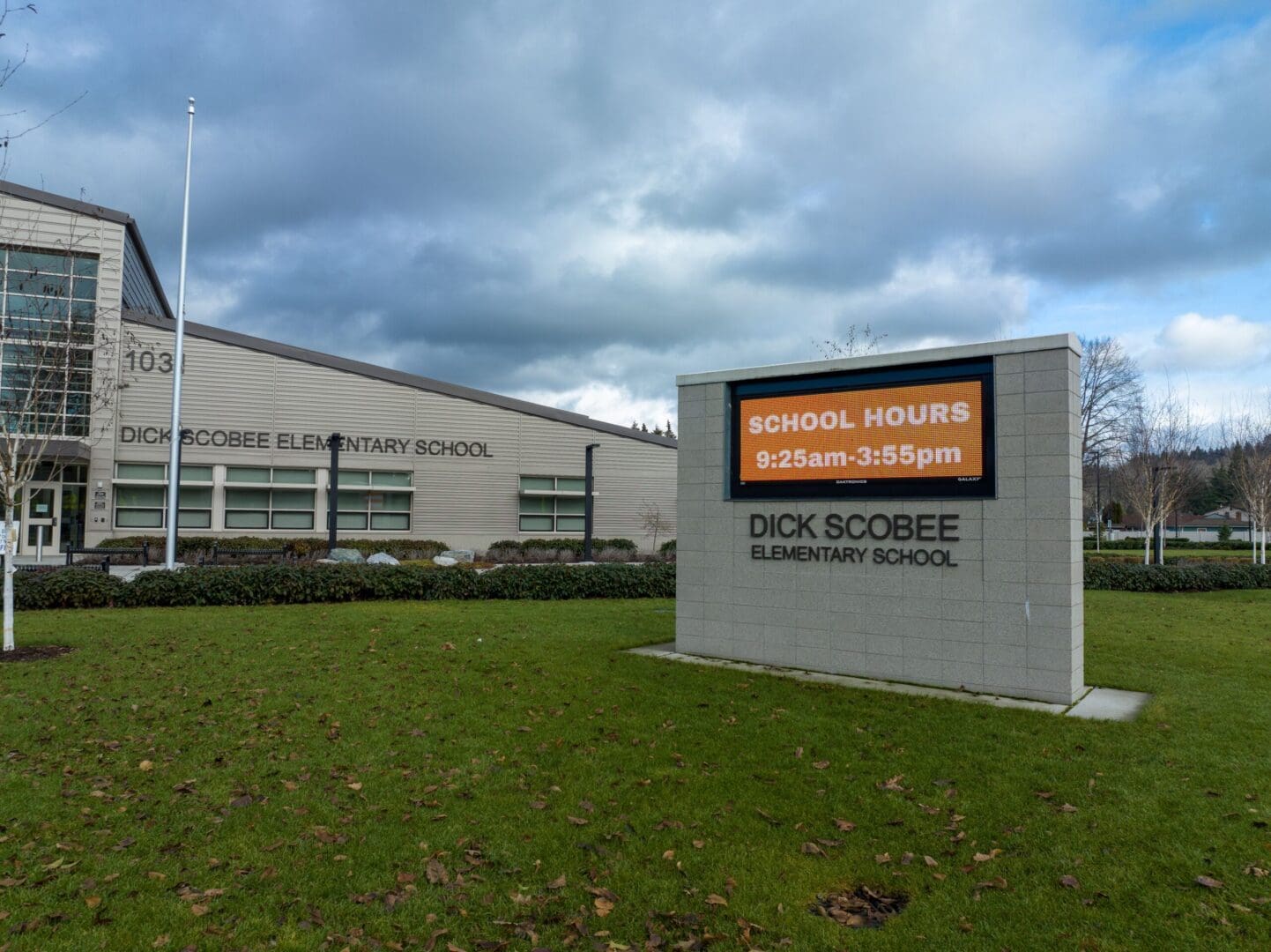 A school building with a sign in front of it.