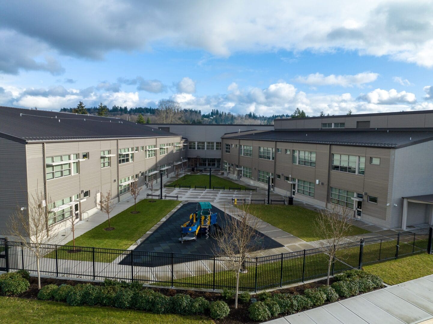 An aerial view of a school building with a playground.