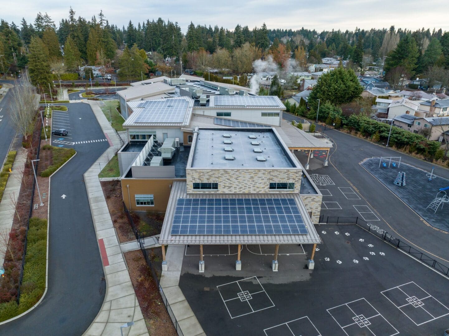 An aerial view of a school with solar panels on the roof.