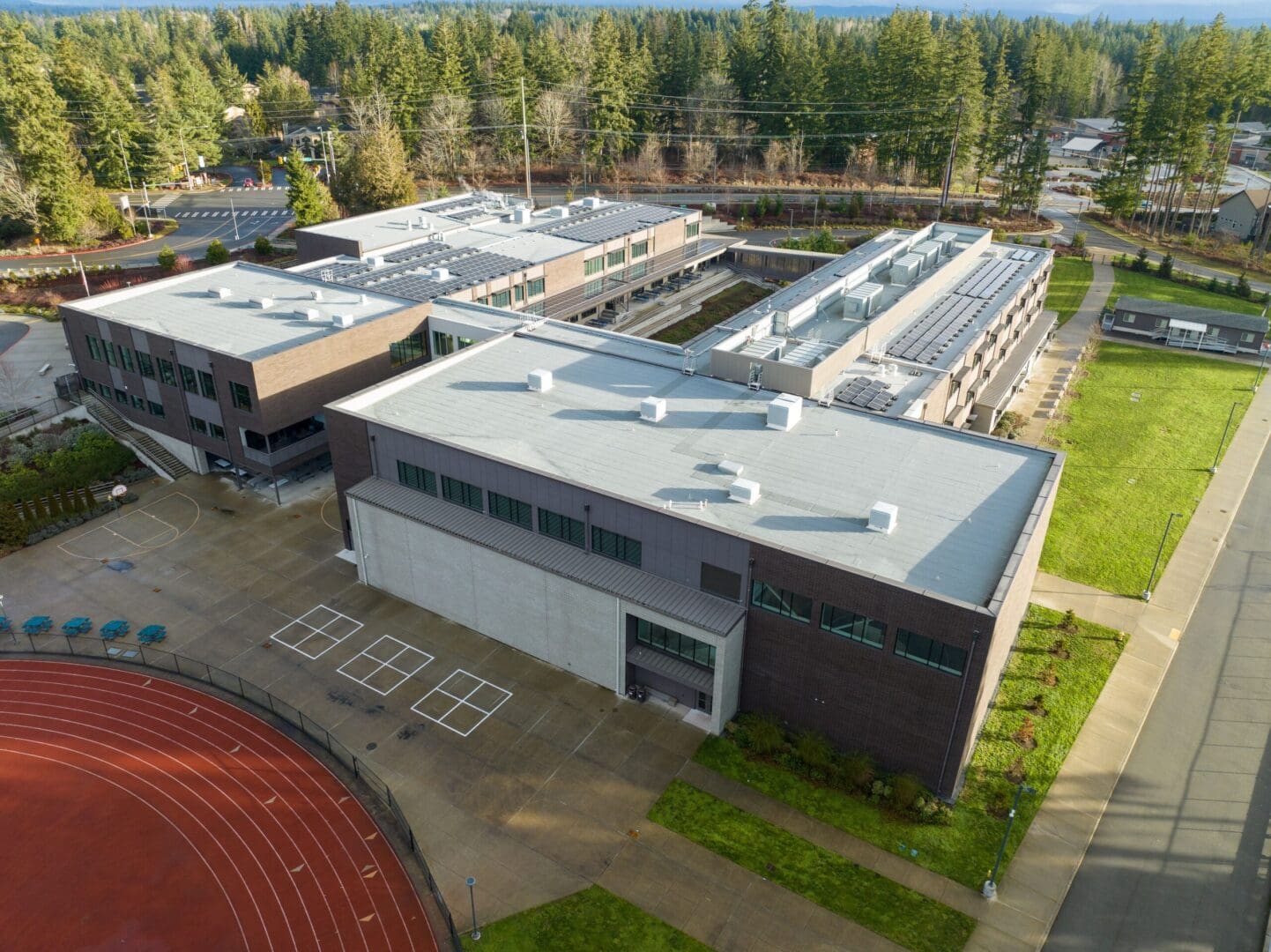 An aerial view of a school building with a track in the background.