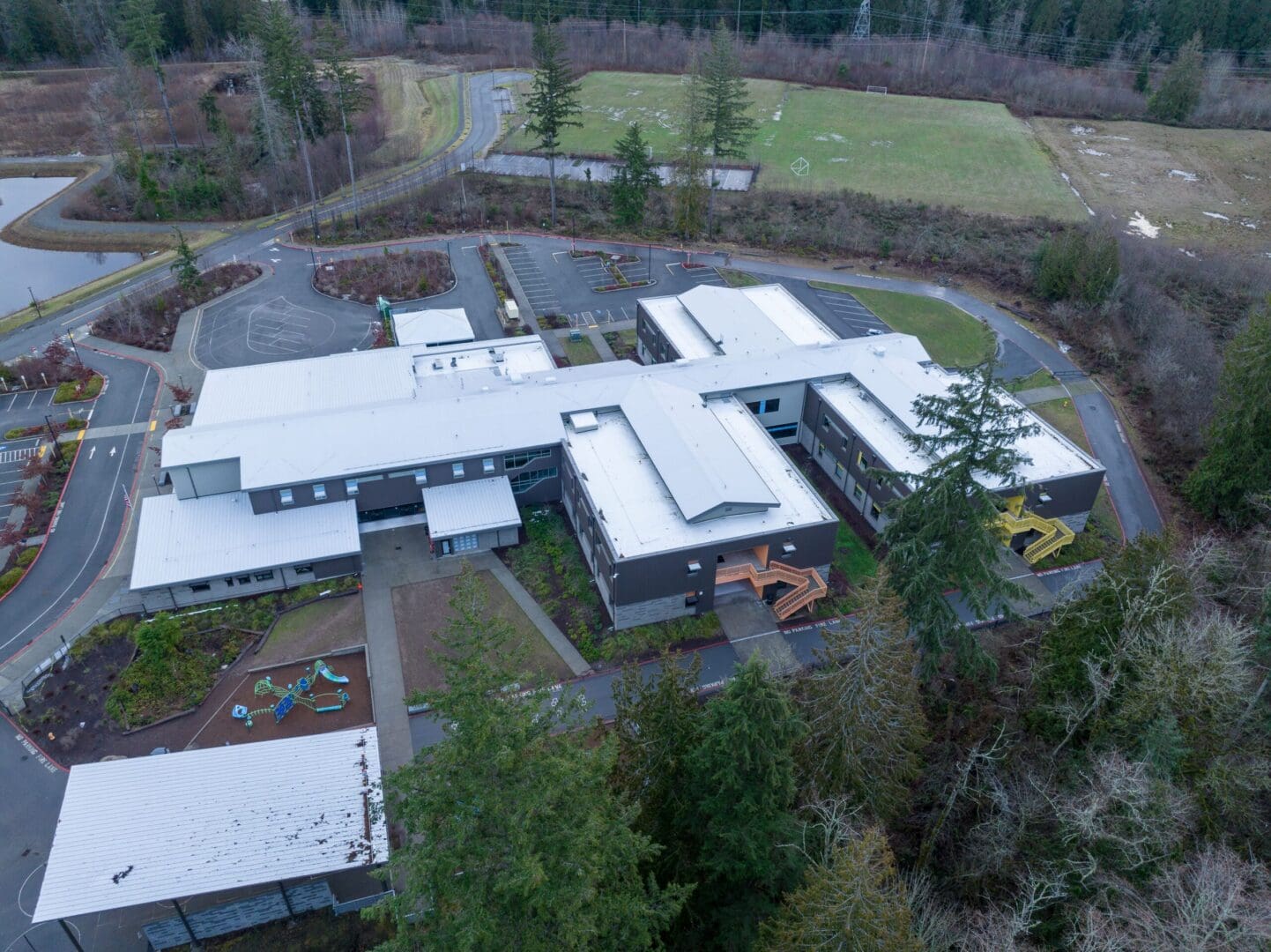 An aerial view of a school building in a forest.